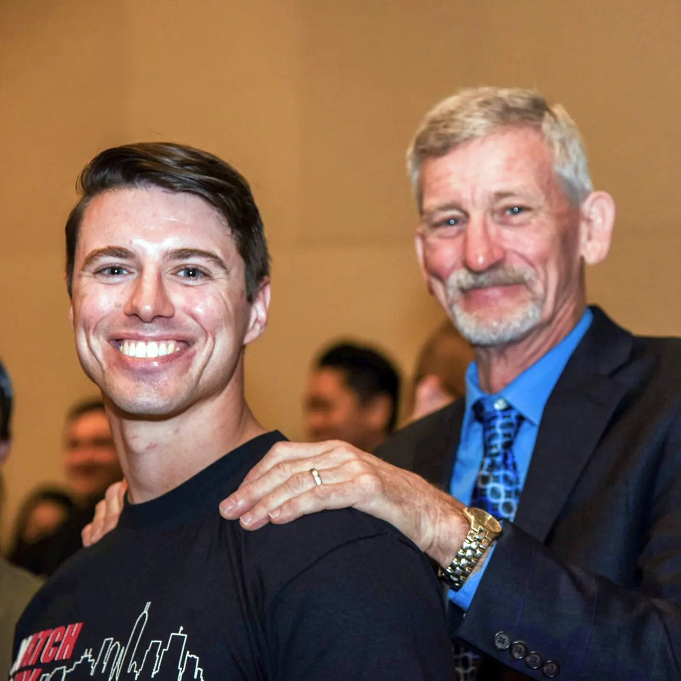 a father rests his hands on his son's shoulders during match day