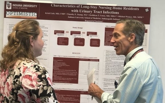 Kristi Lieb and Tom Imperiale speak during a poster presentation.