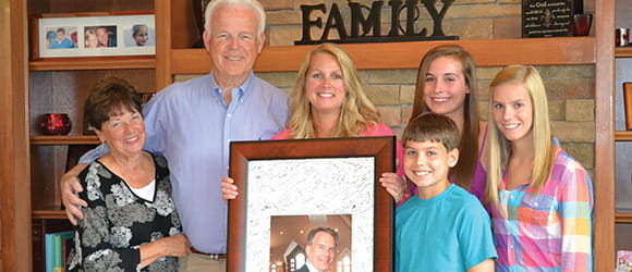 bigelow family holds a photo of their loved one