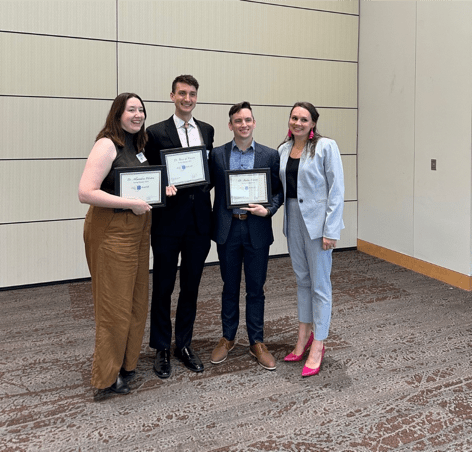 Dr. Emily Fitz smiles alongside presenters at the Indiana ACEP  conference. 