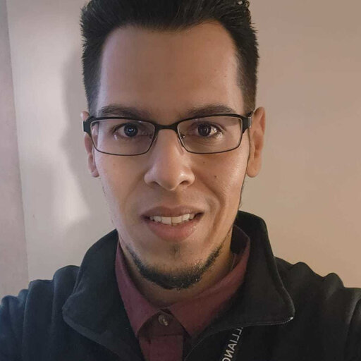 Young man's face, he is wearing glasses and has a goatee