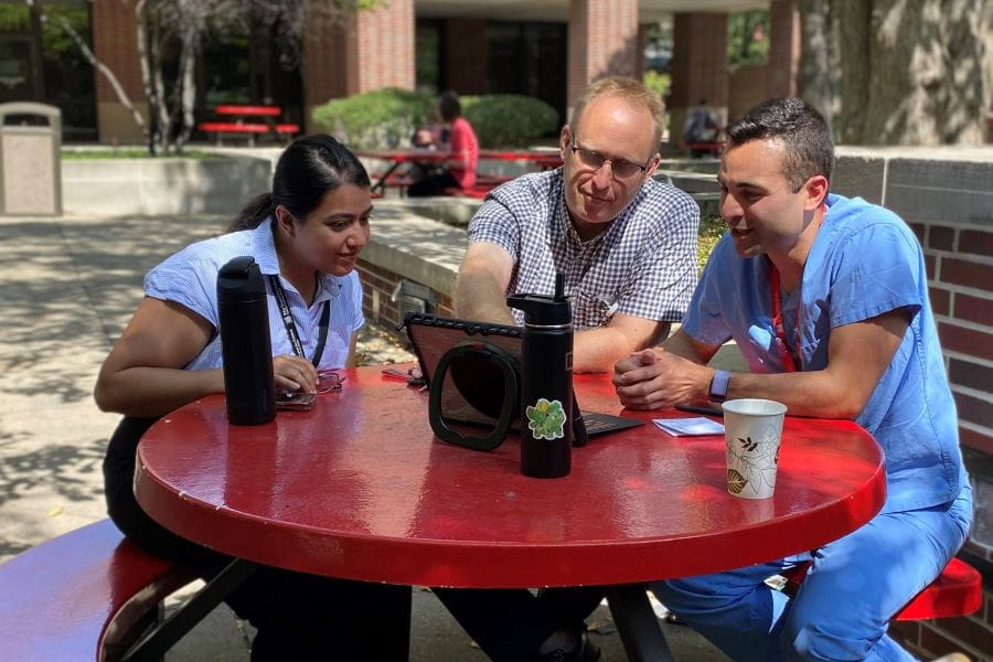Pediatric Nephrology fellows sit outside and work together on a computer