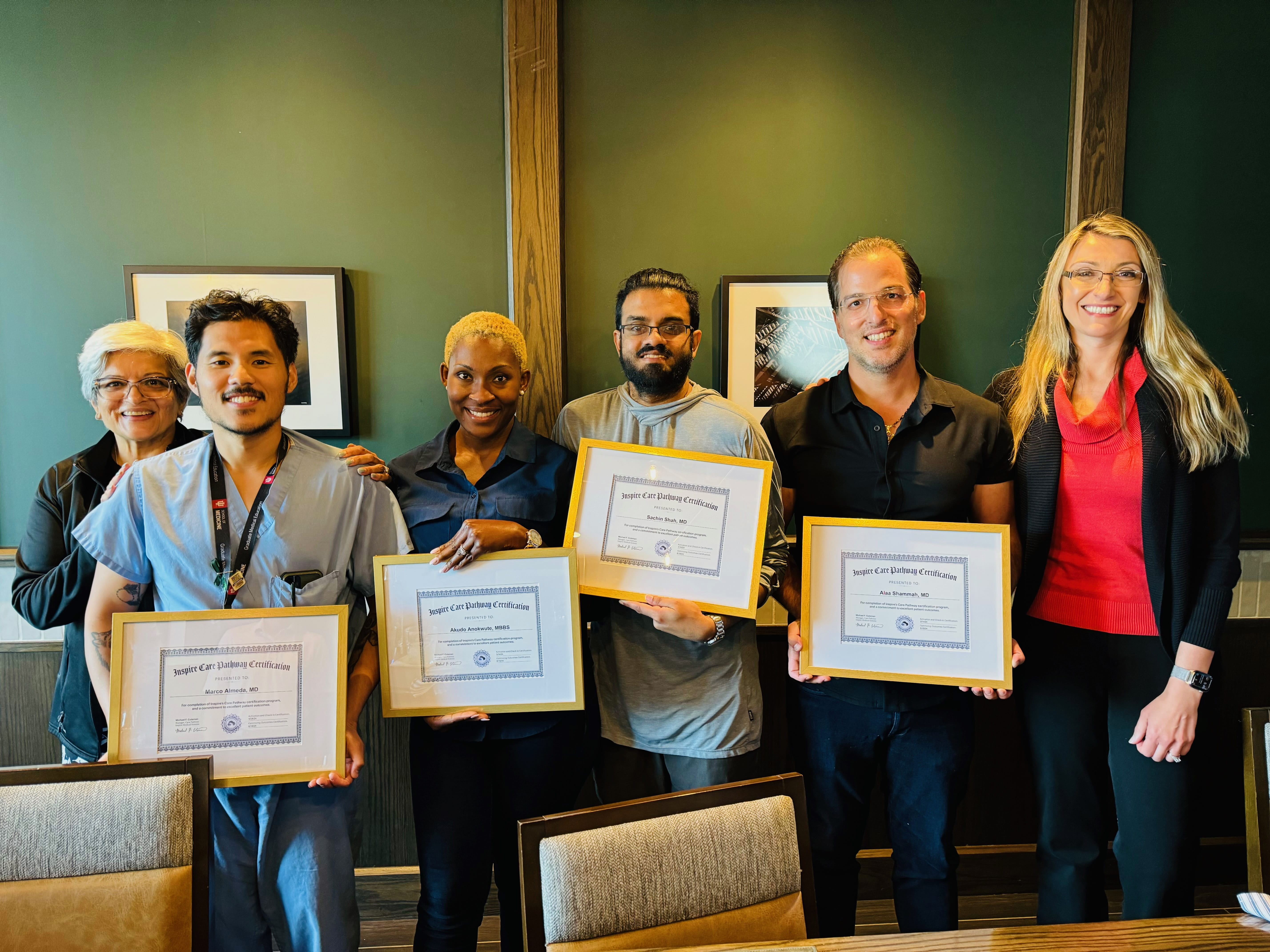 four Sleep Medicine fellows hold their graduation certificates and smile