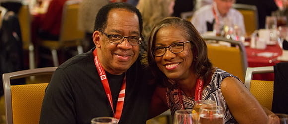 an older black couple smile at the alumni dinner