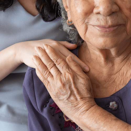 Younger woman with hand on older woman's shoulder