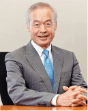 Tadataka wearing suit sitting at desk