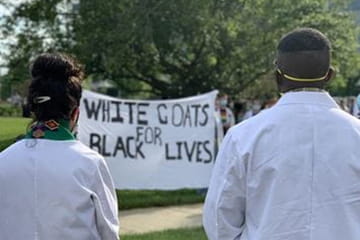 medical students looking at White Coats for Black Lives banner 