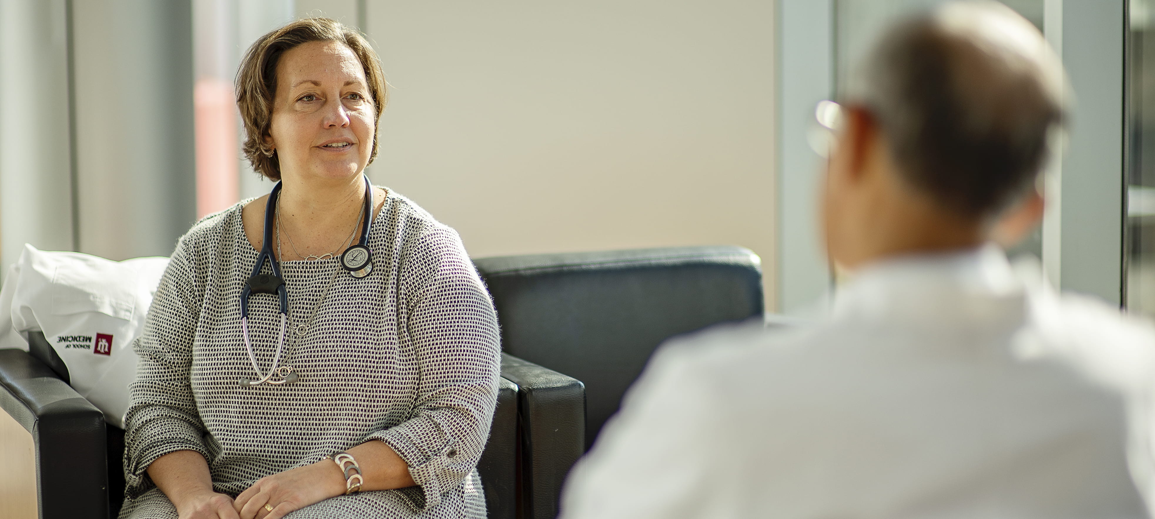 Dr. Kathy Miller sitting across from an individual having a conversation