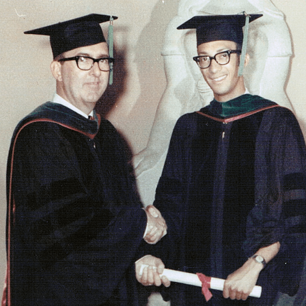 Lester Thompson receives his diploma and shakes the dean's hand