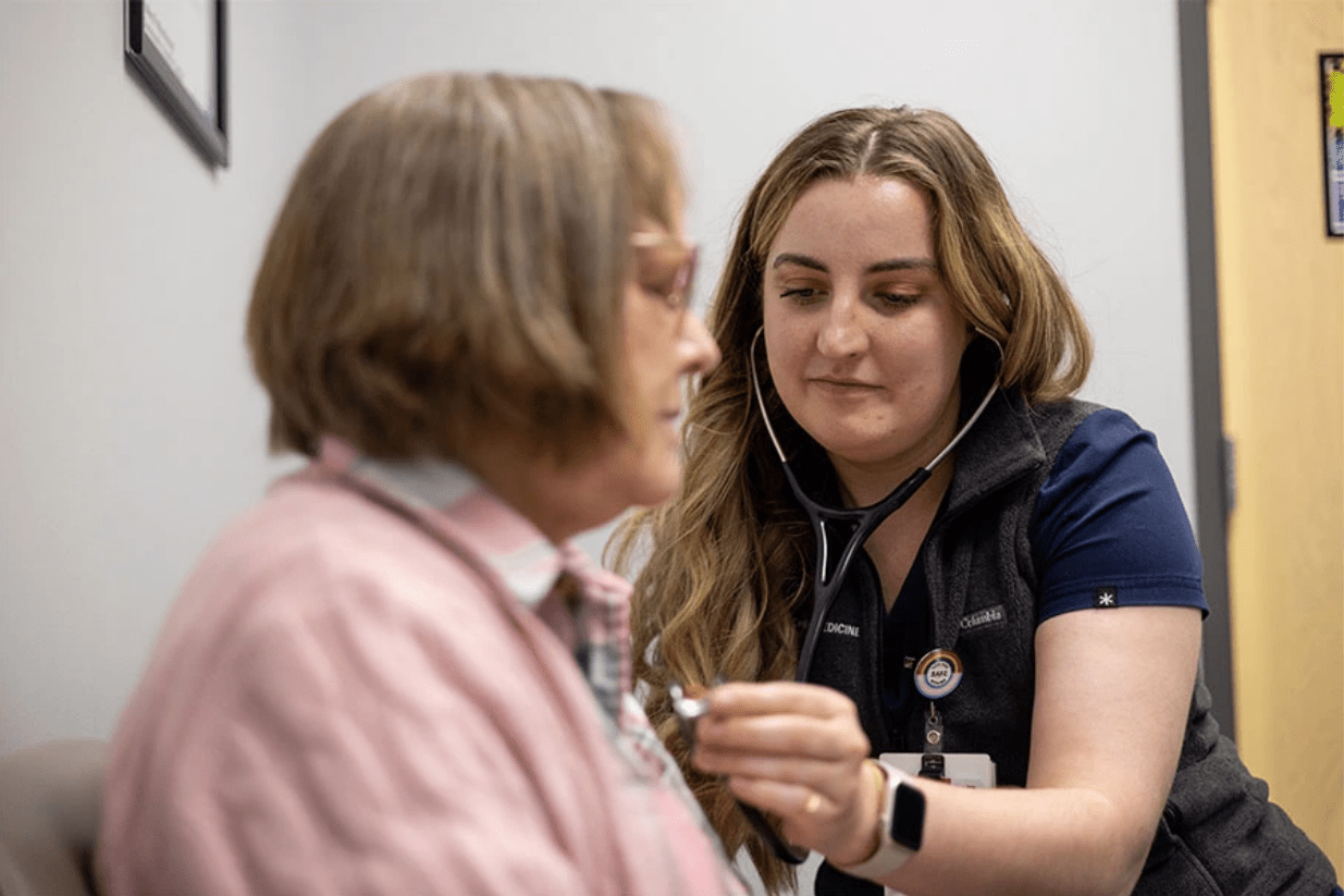 An IU med student listens to a patient's chest with a stethoscope.