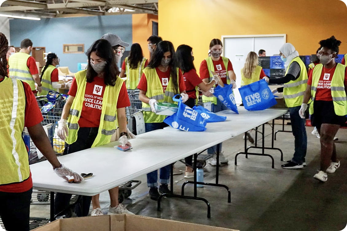 students pack food bags during a service learning event at the foodbank of northwest indiana
