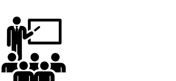 a person presenting at the front of a room of students