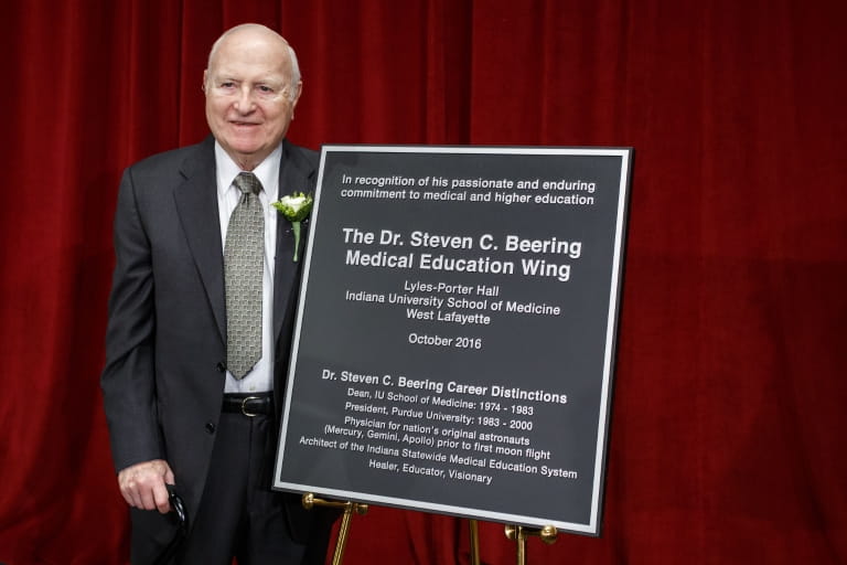Dr. Steven Beering stands with the plaque honoring him at Walther Hall Auditorium on Oct. 17, 2016.