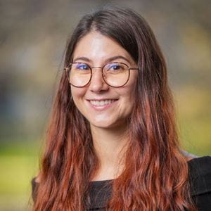 Carla wearing glasses with long wavy brown hair