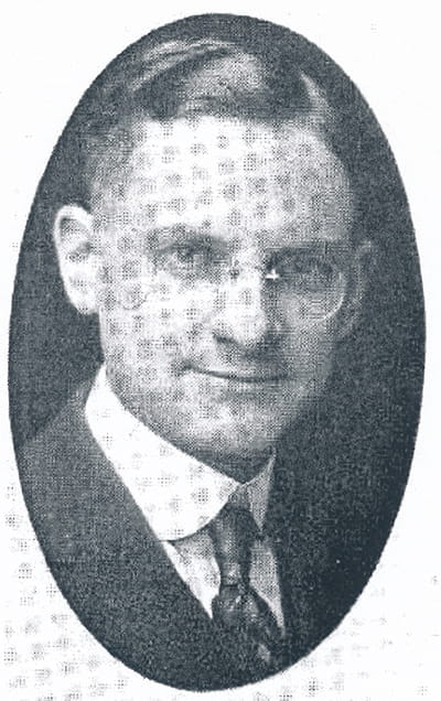 Black and white oval portrait of Dr. Forry, wearing a suit and tie and glasses