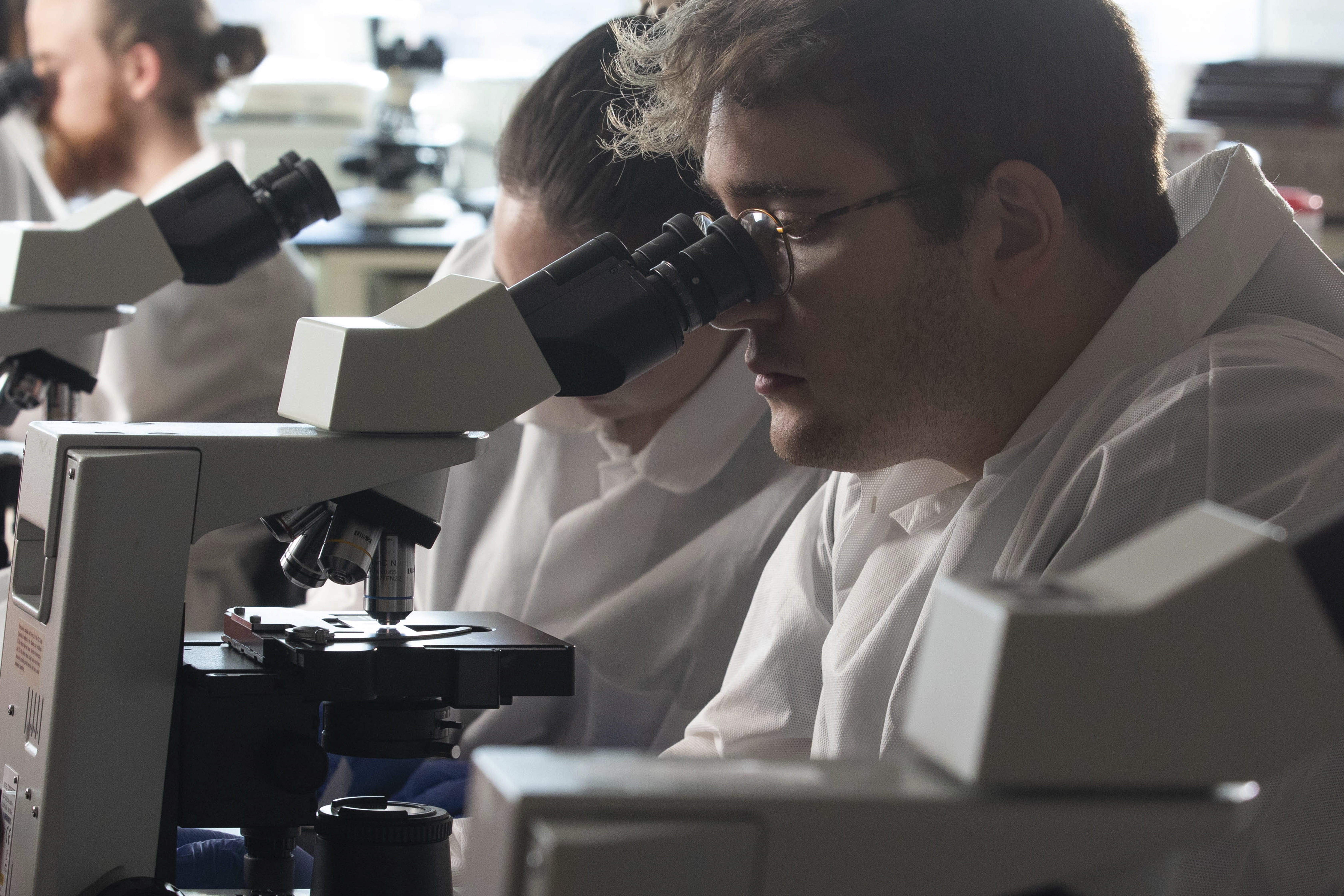 Hystotechnology student looking at a microscope