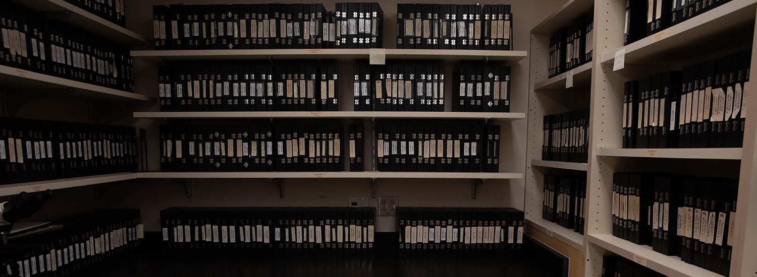 Rows of neatly organized binders line the shelves of an archival storage room, each labeled and carefully cataloged. The scene captures the commitment to preserving valuable records, ensuring easy access to historical data for future research and reference.