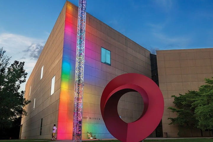 Art museum with large oval sculpture and rainbow lighting displayed on the building