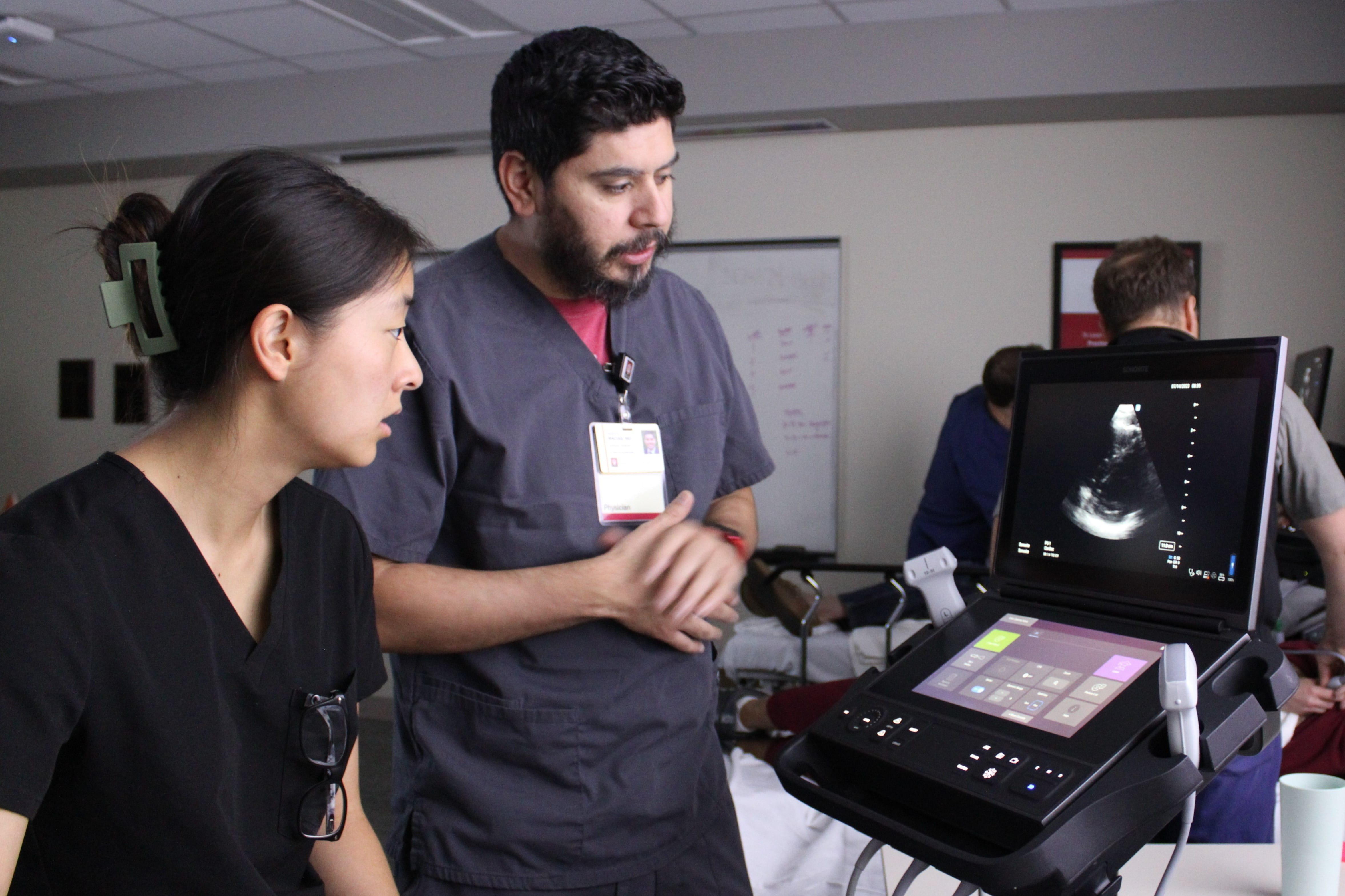 two providers look at an ultrasound screen