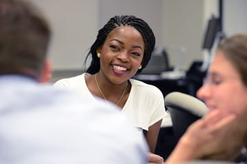a black woman smiles at an educational event