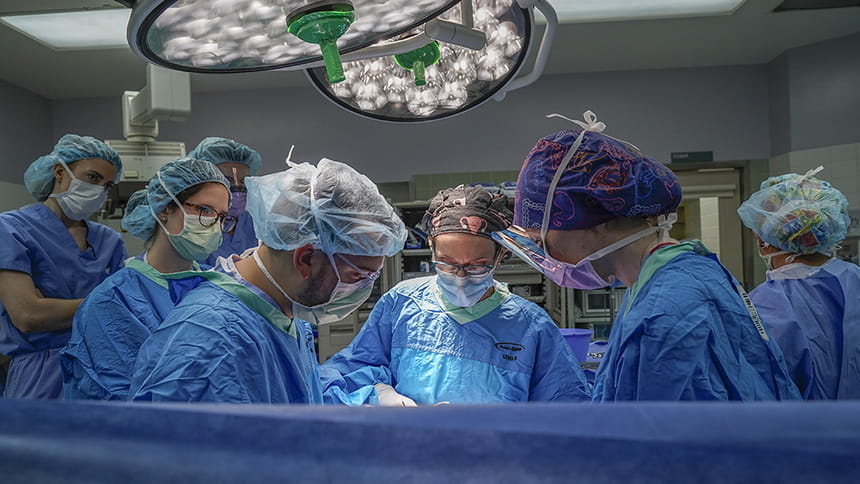 a group of faculty and fellows perform surgery in the OR